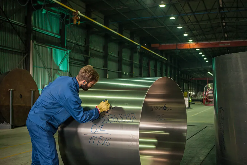 technician marking rolled aluminum plate