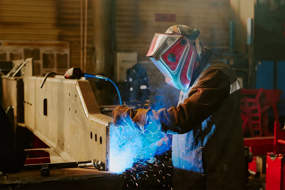 worker welding a structural boom section